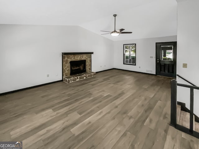 unfurnished living room with lofted ceiling, a fireplace, ceiling fan, and hardwood / wood-style floors