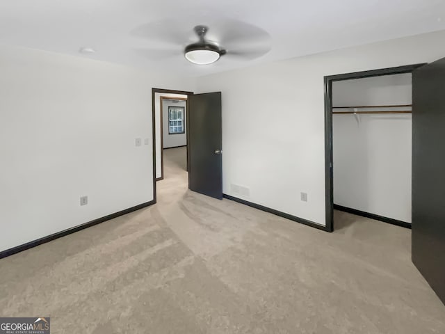 unfurnished bedroom with light carpet, ceiling fan, and a closet