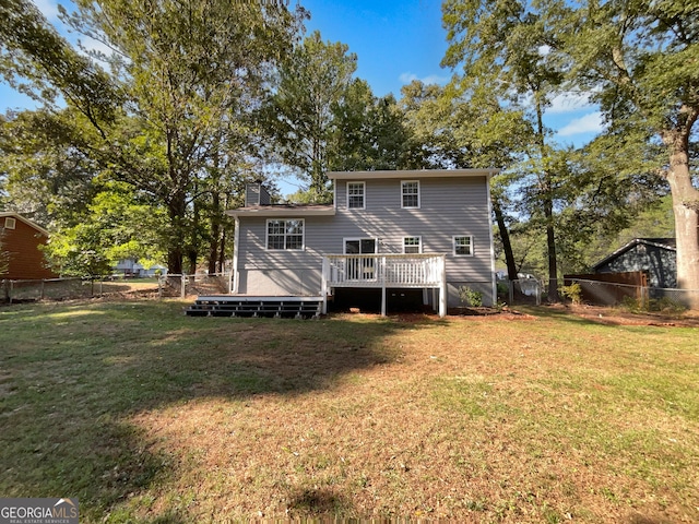 rear view of house with a deck and a lawn