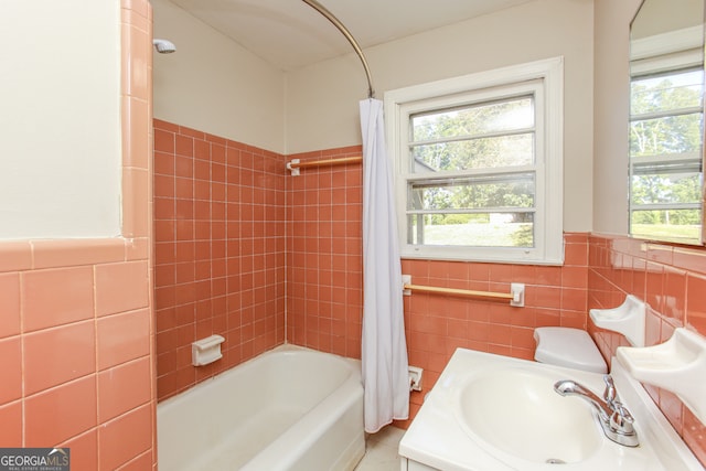 full bathroom featuring vanity, toilet, tile walls, and shower / bath combo