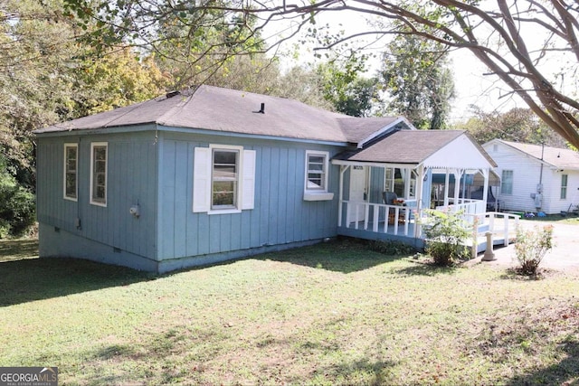 back of house with a deck and a lawn