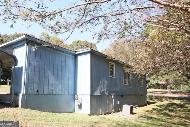 view of side of property with cooling unit and a yard