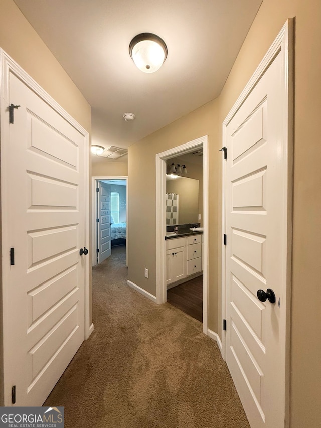 hallway with dark colored carpet