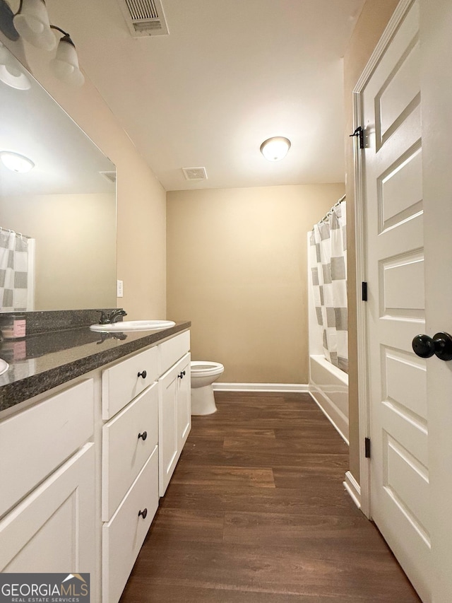 full bathroom featuring vanity, hardwood / wood-style floors, toilet, and shower / tub combo