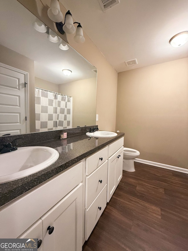 bathroom featuring vanity, hardwood / wood-style floors, and toilet