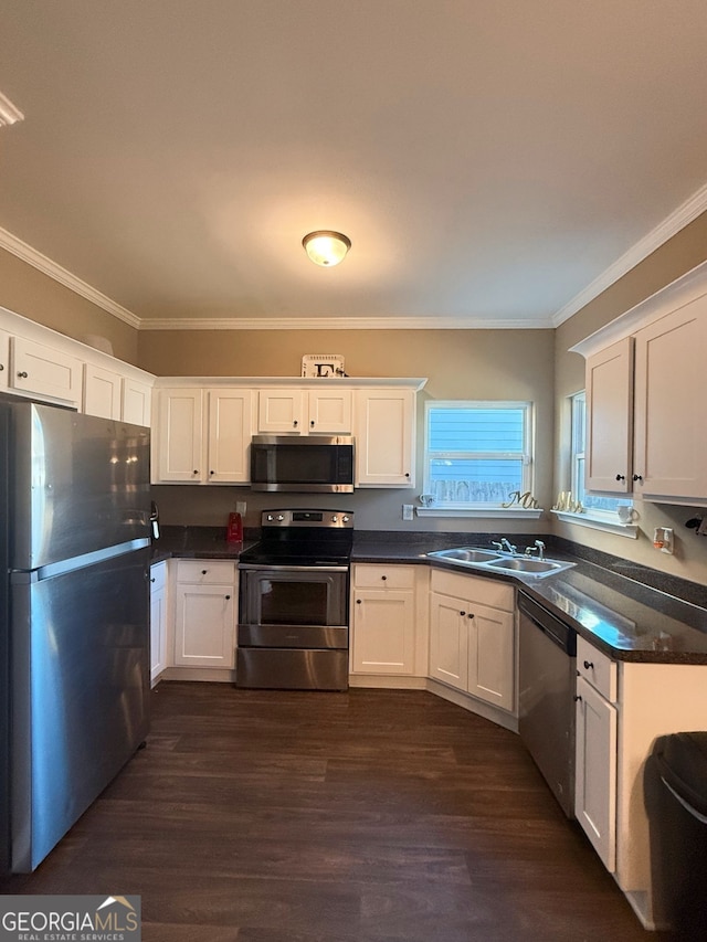 kitchen with ornamental molding, appliances with stainless steel finishes, dark hardwood / wood-style flooring, and white cabinetry