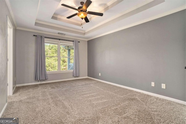 spare room featuring crown molding, ceiling fan, carpet floors, and a raised ceiling