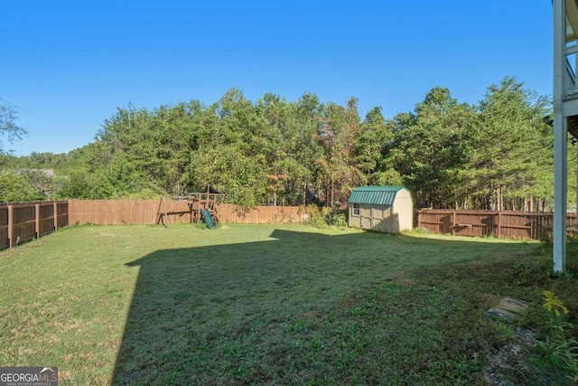 view of yard featuring a playground and a storage unit