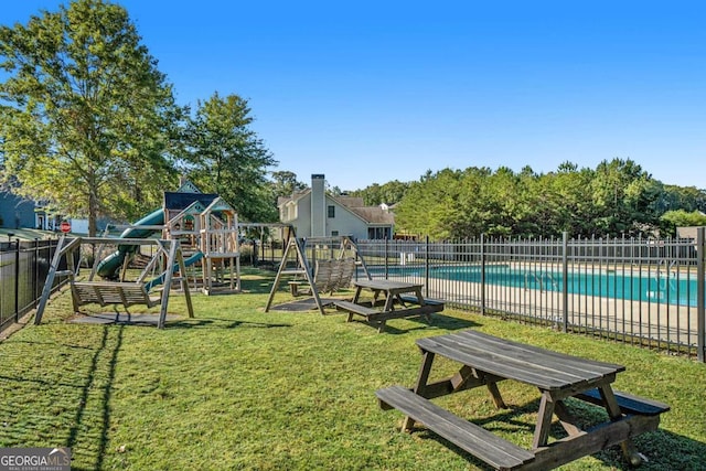 view of play area featuring a yard and a fenced in pool