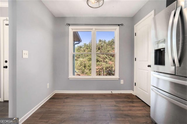 unfurnished dining area featuring plenty of natural light and dark hardwood / wood-style flooring