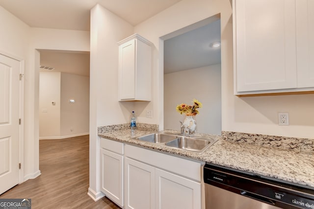 kitchen with light stone countertops, sink, light hardwood / wood-style floors, white cabinetry, and dishwasher