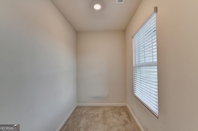 unfurnished room featuring light colored carpet