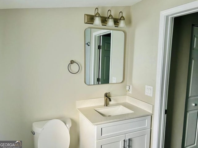 bathroom with lofted ceiling, vanity, and toilet