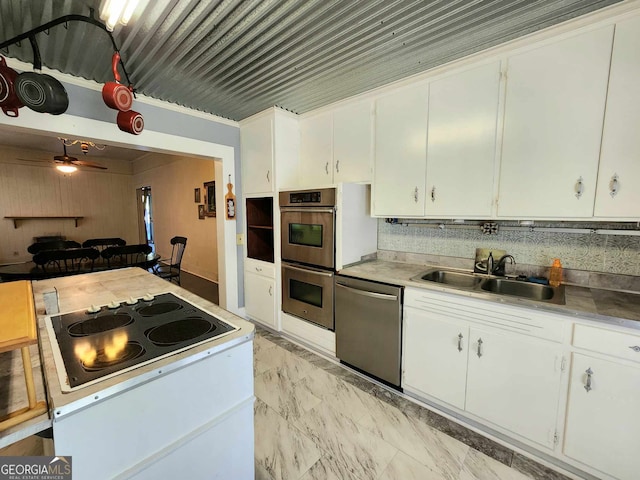 kitchen featuring ornamental molding, appliances with stainless steel finishes, sink, and white cabinetry