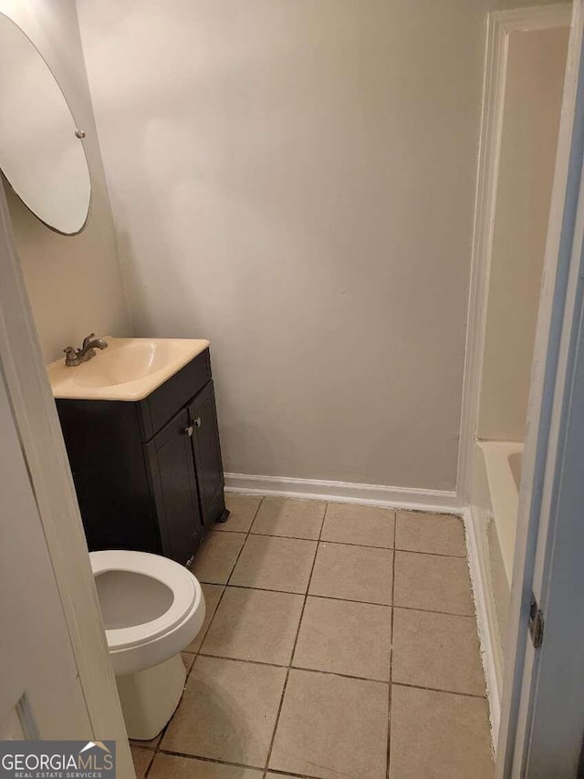 bathroom with vanity, a tub to relax in, tile patterned flooring, and toilet