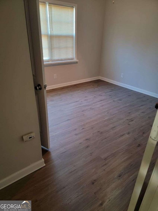 spare room featuring dark wood-type flooring