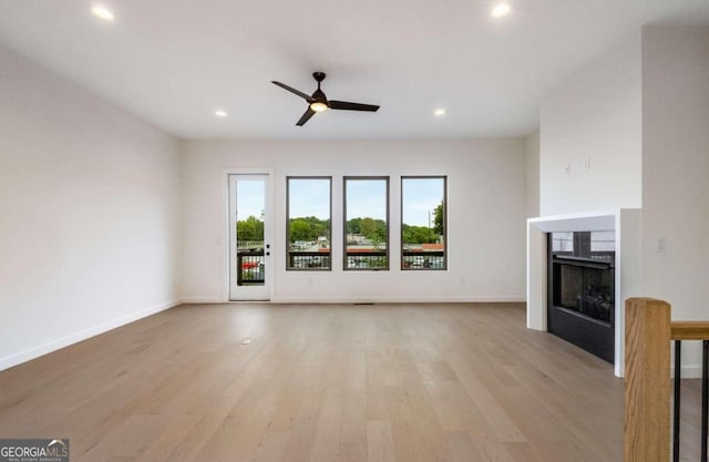 unfurnished living room with ceiling fan and light hardwood / wood-style flooring