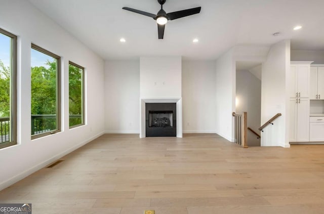 unfurnished living room featuring ceiling fan and light hardwood / wood-style floors