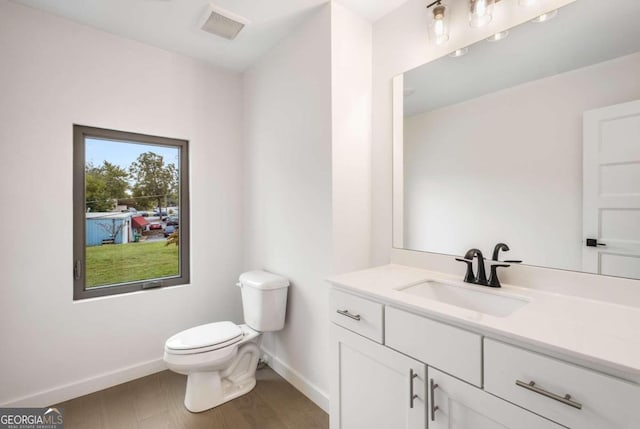 bathroom featuring vanity, toilet, and hardwood / wood-style flooring