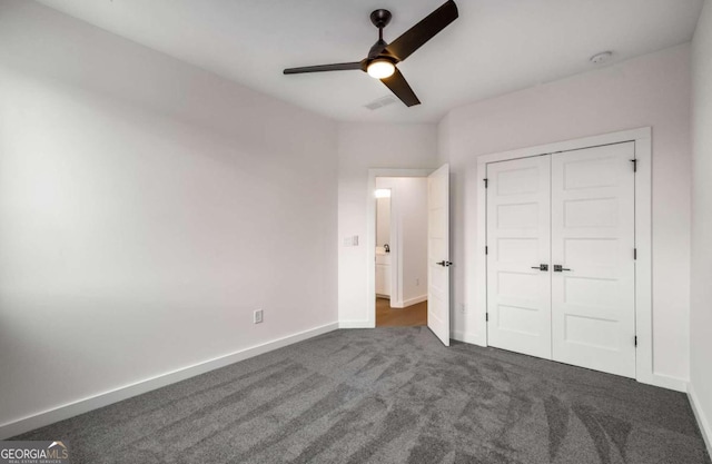 unfurnished bedroom with a closet, dark carpet, and ceiling fan