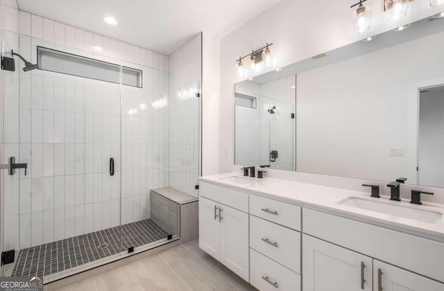 bathroom with tile patterned floors, a shower with door, and vanity