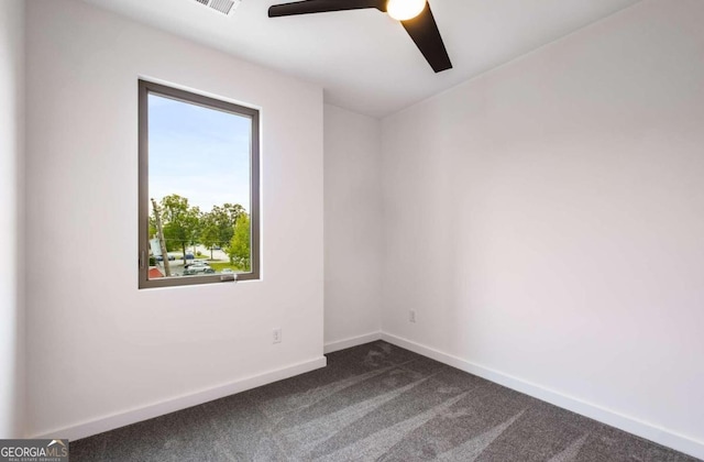 empty room with dark colored carpet and ceiling fan