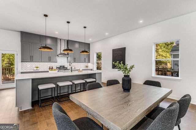 dining room featuring recessed lighting, plenty of natural light, dark wood-style flooring, and baseboards