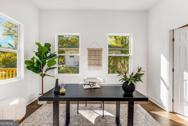 home office with plenty of natural light and dark hardwood / wood-style floors