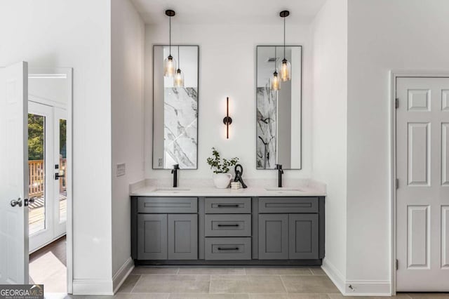 bathroom with double vanity, a sink, and baseboards