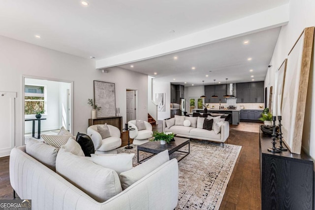 living room with beamed ceiling and dark wood-type flooring