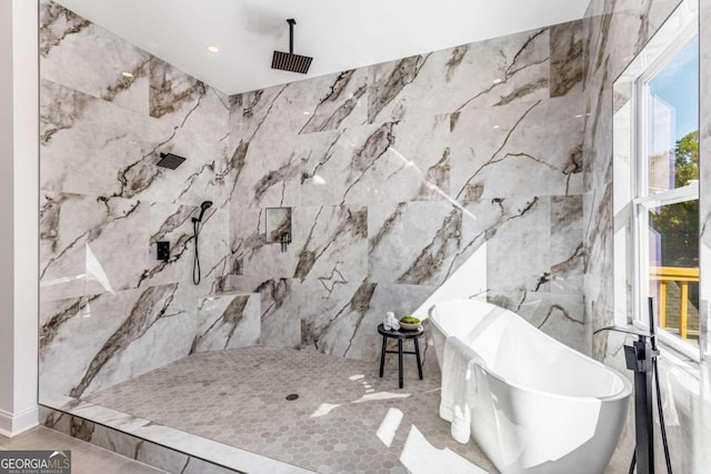 bathroom featuring a freestanding bath, recessed lighting, tile walls, and a marble finish shower
