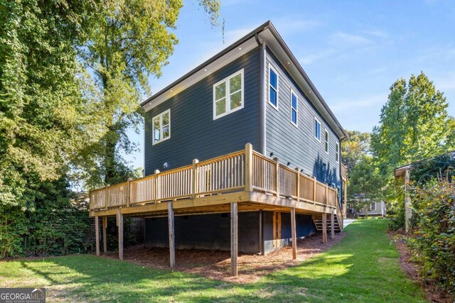 rear view of house with a yard and a deck