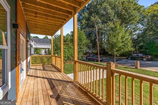 wooden deck featuring a yard and covered porch