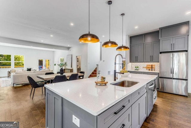 kitchen featuring tasteful backsplash, recessed lighting, gray cabinets, appliances with stainless steel finishes, and a sink