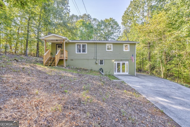 view of front of home featuring driveway, french doors, and crawl space