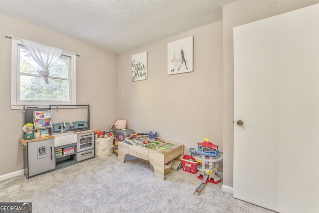 recreation room featuring light carpet and baseboards