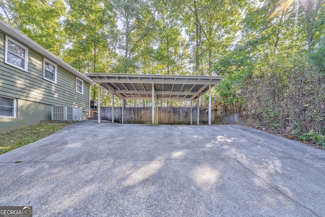 view of parking with driveway and fence