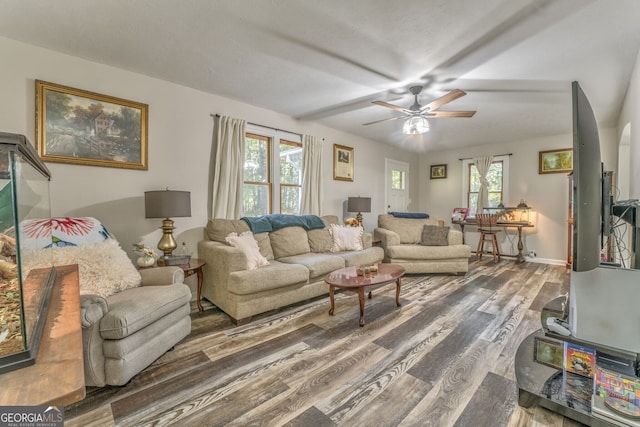 living room with dark wood-style floors, ceiling fan, baseboards, and arched walkways