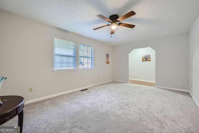 spare room with light carpet, a textured ceiling, and ceiling fan