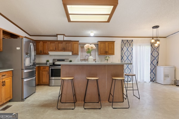 kitchen with a kitchen bar, a center island, decorative light fixtures, and stainless steel appliances