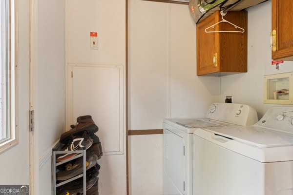 laundry area with washing machine and dryer and cabinets