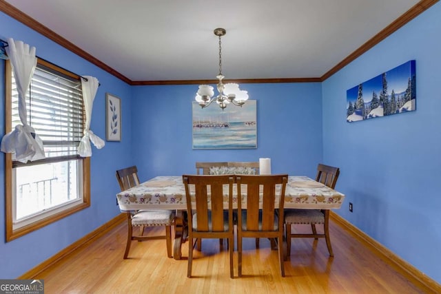 dining room featuring ornamental molding, hardwood / wood-style flooring, and an inviting chandelier