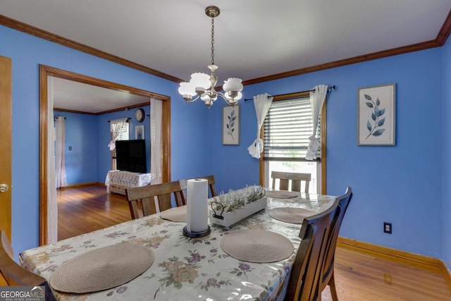 dining area with crown molding, an inviting chandelier, and wood-type flooring