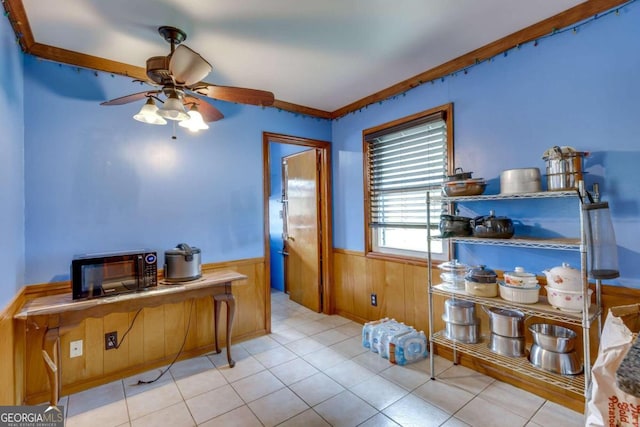 office featuring ceiling fan, light tile patterned floors, wood walls, and ornamental molding