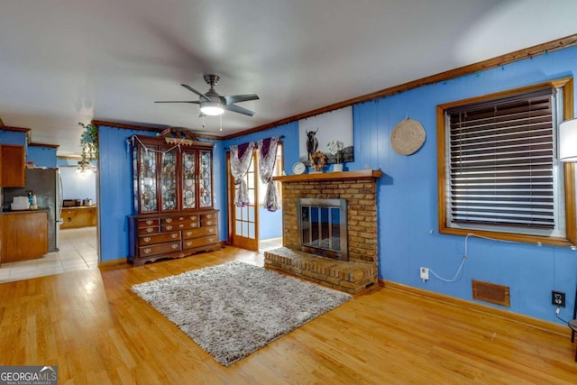 unfurnished living room with a fireplace, ornamental molding, hardwood / wood-style floors, and ceiling fan