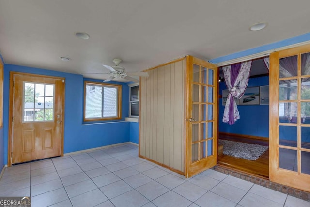 foyer entrance featuring light tile patterned flooring and ceiling fan