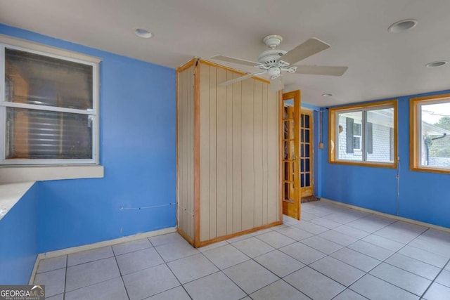 empty room featuring ceiling fan and light tile patterned floors