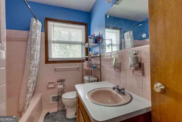 full bathroom with shower / tub combo, toilet, tile walls, and vanity