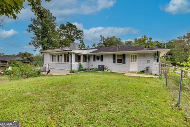 rear view of house featuring a yard and central air condition unit