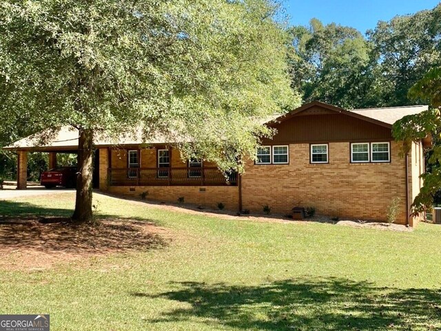 view of home's exterior featuring a carport and a lawn